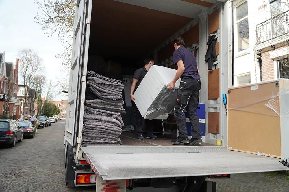 Verhuizers van Oomen verhuizers helpen met het inladen van een container.