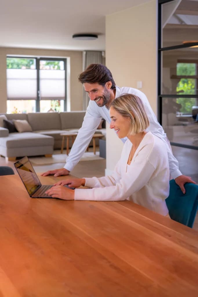 Man en vrouw vragen samen op een laptop een verhuisofferte aan