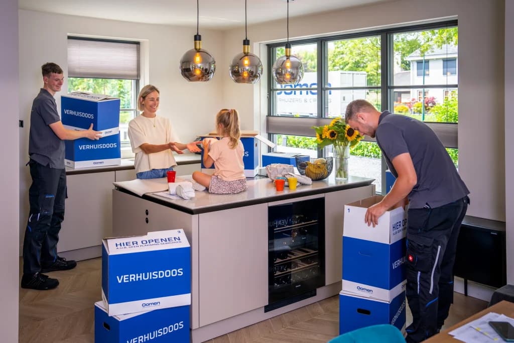 Verhuizers van Oomen dragen verhuisdozen de keuken van een woning binnen