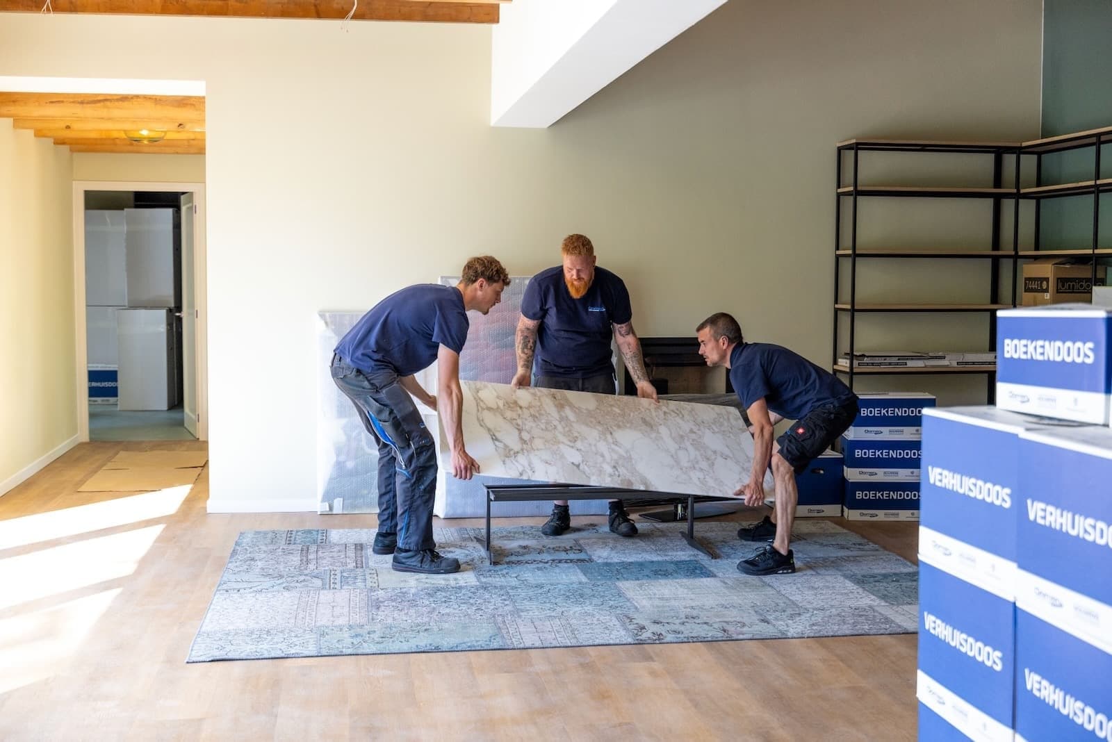 Verhuizers van Oomen tillen meubels tijdens een verhuizing