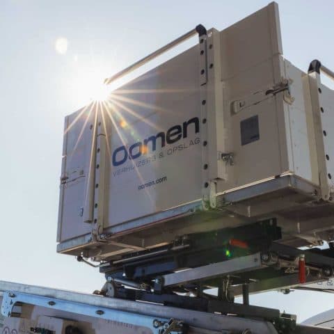 Oomen storage container on the truck's loading system in the sun