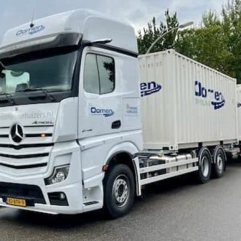 Oomen truck transporting two storage containers