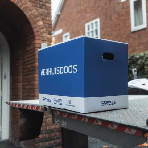 Blue Oomen moving box on the tail lift in front of a house