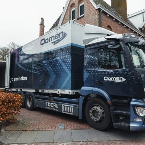 Electric Oomen moving truck with zero-emission lettering in a residential area